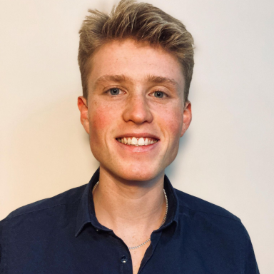 Photo of Tom Luton smiling and wearing a blue buttoned shirt.